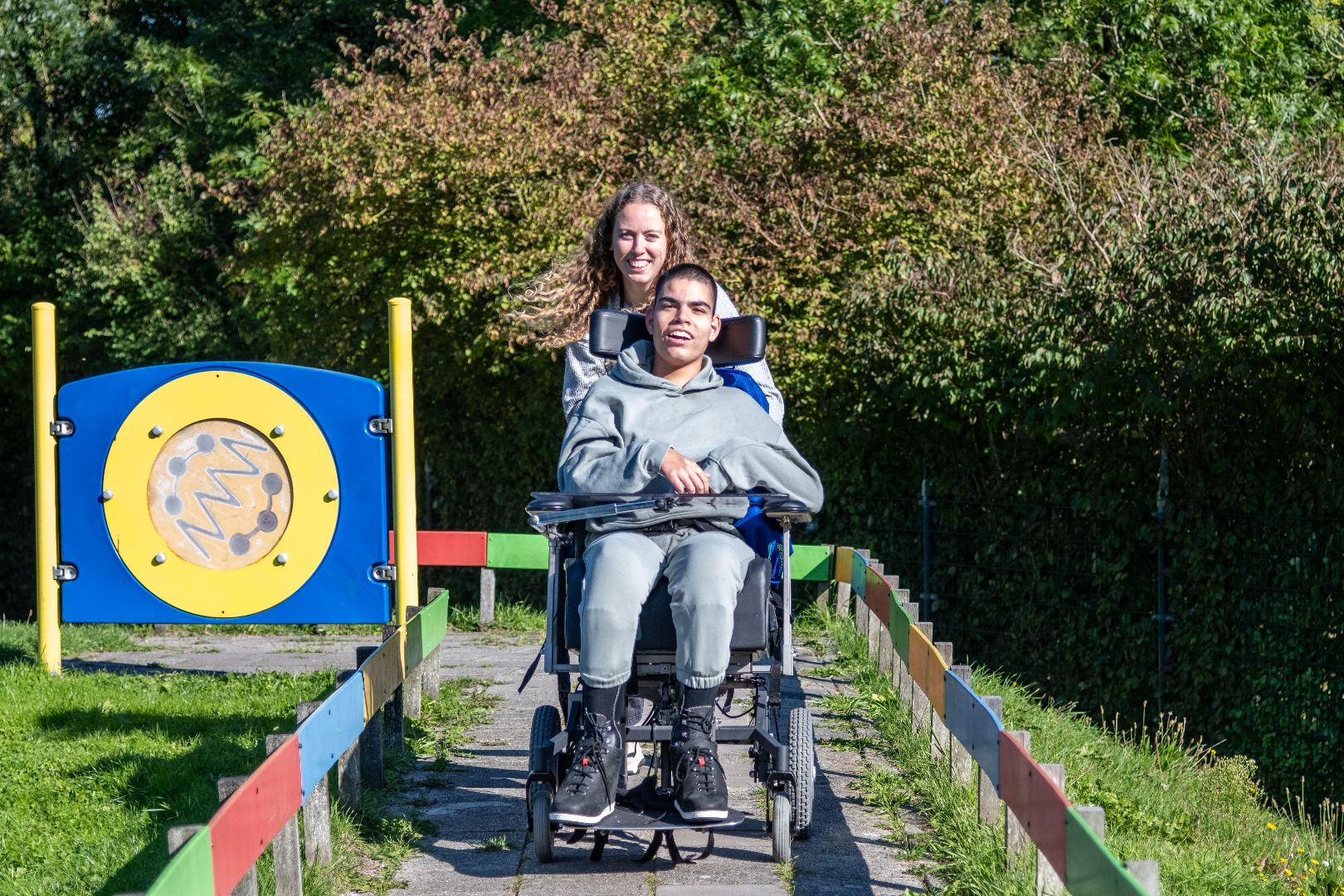 Medewerker van MVG met een lachend kind in rolstoel