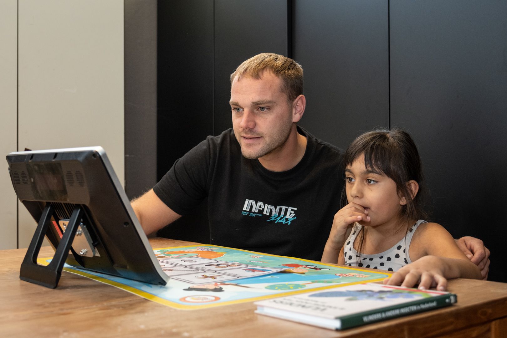 MVG Zorg medewerker met een kind kijkend naar een tablet