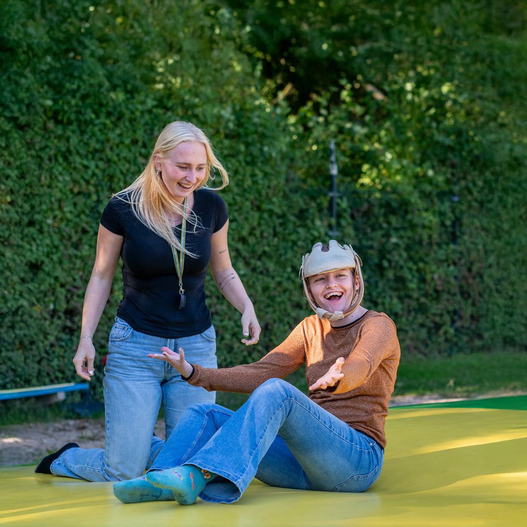 MVG Zorg medewerker met een kind op springkussen aan het lachen